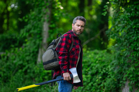 Lumberjack man with an axe in the forest.