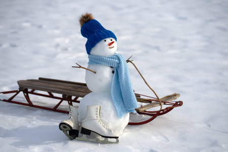 Snowman winter background. Snow holiday scene. Festive snowman with scarf. Snowy landscape design. Happy snow-man with hat. Christmas banner. Frosty snowman. Winter greeting postcard. Funny snowman.の写真素材