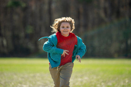 Child run fast in park. The child runner run and sprint outdoors. Kid run with fun. Outdoor sports kids healthy. A child runs through nature. The run motion of carefree kid. Running and jogging kids.の写真素材