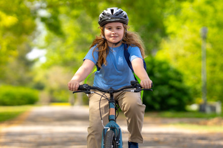 Child bike ride. Teen boy biking down summer road. Kid riding bicycle with smile. Child cycling. Kid ride on bike. Happy boy on bike. Child biking outdoors. Children biking. Little biker.の写真素材