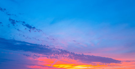 Sky at sunset. Sunrise over horizon. Sunlight shining through clouds on sky. Twilight sky with vibrant colors. Peaceful dawn with soft light. Dramatic dusk with glowing clouds. Sunshine in clear sky.の写真素材