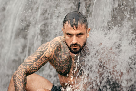 Muscular body. Healthy muscular male body under waterfall. Strong topless man splashing in nature. Fit and male torso. Athletic body. Physical strength and wellness. Man beauty, body balance.の写真素材
