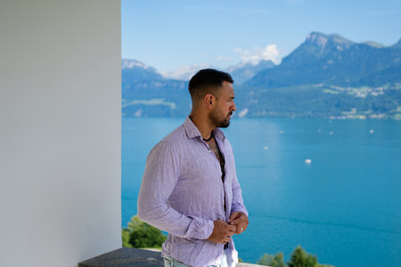 A muscular man relax on mountain Alps landscape. A handsome tourist man on alpine lake. A strong man posing in summer nature. A dreamy, carefree traveler. Man freedom in the outdoors.の写真素材