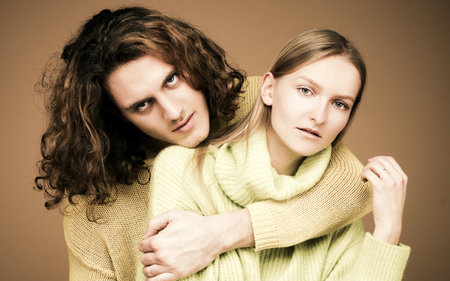Young couple. Couple posing for the camera against yellow studio wall. Couple in love. Sensual...