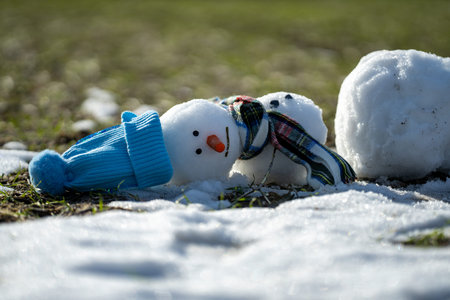 Snowman is melting on warm winter day. Hello spring. Melted snow, winter weather, anomaly weather...