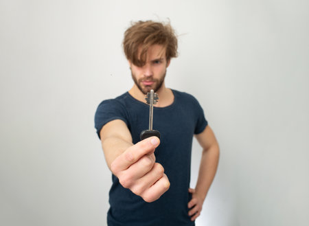 Key concept. Keys to success. Crazy homeowner. Funny guy got the key. Funny security concept with key. Confused guy posing with safety keys. Man with key and funny expression.の写真素材