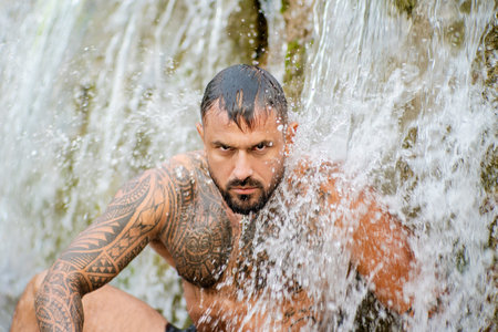 Healthy life strong man outdoors. Fit muscular male summer portrait. Wellness lifestyle man in nature. Athletic guy water splash. Healthy man. Fitness lifestyle. Healthy body. Man in nature.の写真素材