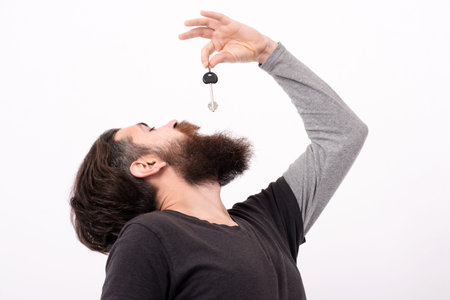 Key concept. Keys to success. Crazy homeowner. Funny bearded man got the key. Funny security concept with key. Confused guy posing with safety keys. Secure access. Man with key and funny expression.の写真素材