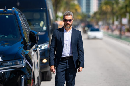 Rich business man near a luxury car. Rich businessman in suit outdoors. Successful rich business man...