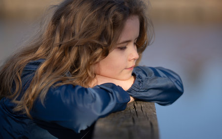 Childhood imagination. Outdoor portrait of a dreaming kid. Close-up of a child in deep thought. Young thinker enjoying a peaceful moment. Innocent child imagining the future. Sweet little dreamer.の写真素材