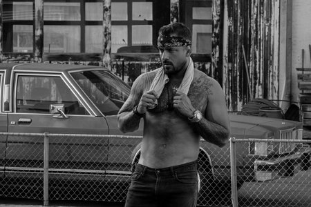 Portrait of handsome hipster hispanic model. Sexy modern man in the street. Fashion male posing on street background. Man street gang, social problem. Criminal city. Danger american district.の写真素材