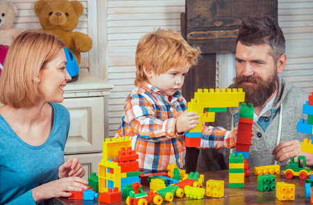 Family playing with colorful plastic building blocks at home. Family playing with child. Mother and father play with their son. Kid playing creativity. Family playing with child.の写真素材