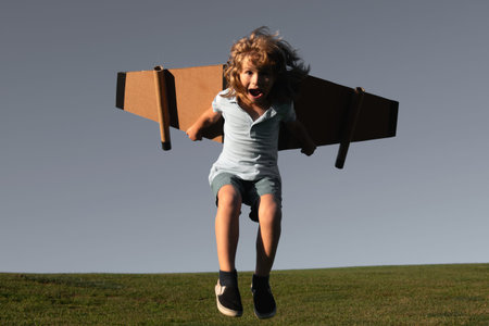 Funny Child jumping and running with toy jetpack. Child pilot astronaut or spaceman dreams of...