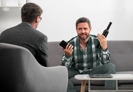 Solving problem, alcohol addiction, man alcohol abuse. Psychology, mental therapy concept. Man and psychologist at psychotherapy session.の写真素材