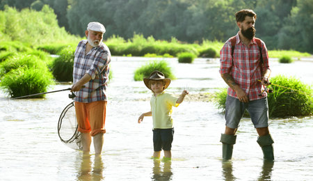Men hobby. Summer day. Male multi generation family. Family fishermen fishing with spinning reel....