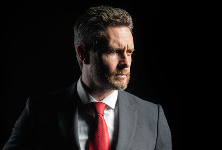 Confident businessman. Middle-age business man in formalwear suit isolated on black. People,...
