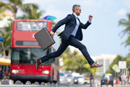 Business jump. Crazy business man jumping in the street. Businessman in a suit running late and jump. Busy business man in jump motion. Confident businessman office worker jump up with excitement.の写真素材