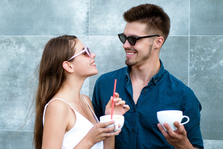 Young couple drinking coffee together. Romantic date with coffee. Man and woman with cup latte....