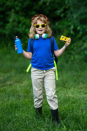 Child enjoying a picnic in summer. Kid Fun on camping. Little tourist on nature. Child enjoying...