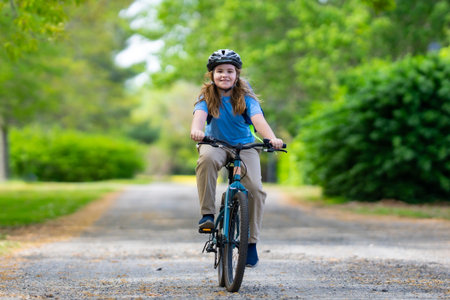 Child bike ride. Child biking down summer road. Kid riding bicycle with smile. Kid cycling. Kid ride on bike. Happy boy on bike. Kid biking outdoors. Children biking. Little biker.の写真素材