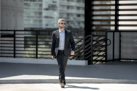 Successful business man walk with on laptop outdoors. Confident business man hold laptop outside. Mature freelancer businessman in suit. Finance business. Rich business man in suit.の写真素材
