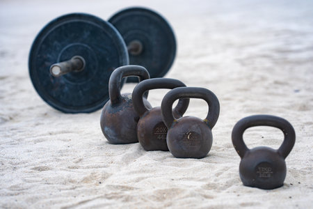 Kettlebell and weights background. Bodybuilding with heavy weights. Park workout with dumbbells. Sports scene with weights. Kettlebell, dumbbells and barbell background. Weights training outdoor.の写真素材