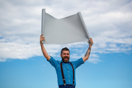 Funny man holding blank board. Hipster guy showing empty board. Guy with cardboard banner board. Man...
