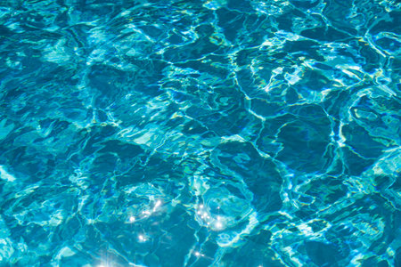 Blue pool water background. Blurred transparent clear calm water surface texture. Water waves in...