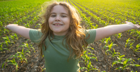 Farmer child work in corn field. Kid in the countryside. Child farmer on field. Harvest season, work on corn farm. Kid planting corn. Little farmer. Kids rural life. Happy little farmer.の写真素材