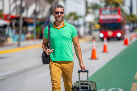Man 40s traveler. Tourist on summer vacation. The travelers luggage for summer trip. Summer tour. A tropical getaway. Spring break. A traveler enjoys summer day. Spring trip.の写真素材