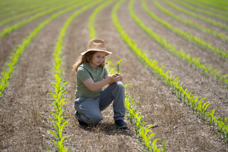 Child helping on farm. Young farmer planting corn. Kid working on farmland. Kid in corn field....