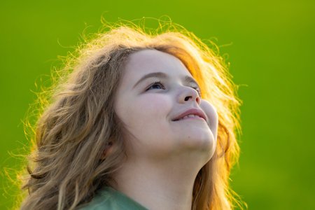 Kid looking away. Child thinking with a doubtful look. Portrait of a child imagining deeply. Dreamy teen child lost in thought. Clever boy with thoughtful face. Daydreaming child showing quiet wisdom.の写真素材