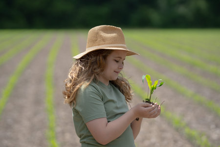Child helping on farm. Young farmer planting corn. Kid working on farmland. Kid in corn field....