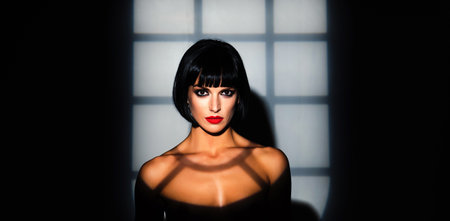Beauty woman portrait in night shadows. Fashion portrait. Sensual brunette model face in night light. Beauty female face. Sexy beauty woman in studio dark light. Beauty portrait.の写真素材