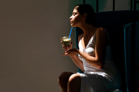 Romantic woman drinking espresso. Attractive woman holding coffee cup. Girl enjoying aromatic latte. Romantic portrait of woman with coffee in cafeteria. Model with coffee glass. Delicious coffee.の写真素材