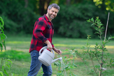 Gardener growing plants in the garden. Farmer plant tree in the home backyard. Man planting a tree....