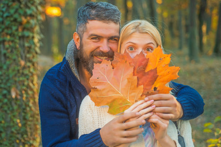 Outdoor autumn couple portrait with sunny day light close up. People in love on Autumn background....