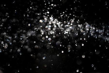 Water drop on black background. Clear droplet on surface. Dripping splashing effect. Splashing waters drops. Falling droplet in motion. Abstract splash drop design. Textured wet backdrop. Water drop.の写真素材