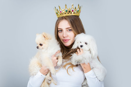 Beautiful girl dressed as a princess hold puppy. Romantic portrait with dog and queen. Lovely girl...
