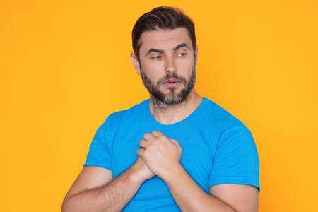 Religion concept. Man praying. Isolated portrait of male pray. Closeup portrait of man praying hands, hoping isolated on yellow background. Human pray.の写真素材