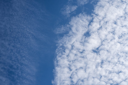 Blue sky with small fluffy white clouds. Scenic cloudscape on a cloudy day. Beautiful cumulus...