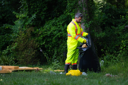 Volunteer man picking plastic trash for cleaning the nature. Clean up garbage outdoor. Ecology...