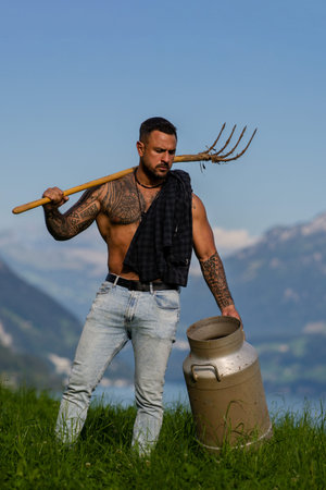 Rural man working on a farm. Farmer working in a field under the sun. Farmer with pitchfork in a...