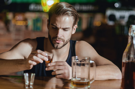 Man sitting alone in pub. Man with alcohol. Sad guy in bar. Guy in dark bar. Alcohol problem. Lonely...