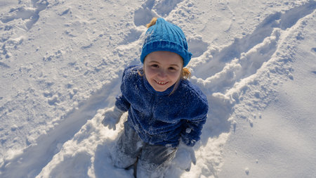 Kid play with snow. Winter child plays with snowflakes. Kids winter holidays. Winter kids portrait....