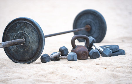 Kettlebell and weights background. Bodybuilding with heavy weights. Park workout with dumbbells....