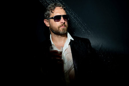 Stressed businessman in suit in bathroom after crisis business. Man drinking a whiskey after stressed office work. Business stress. Stressed business man under shower in bath.の写真素材