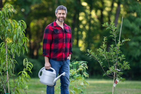 Gardener growing plants in the garden. Farmer plant tree in the home backyard. Man planting a tree....
