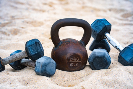 Sport equipment background. Kettlebell barbell and dumbbells for summer sport background. Outdoor sport background. Fitness workout in public sport gym. Healthy lifestyle background. Fitness outdoors.の写真素材