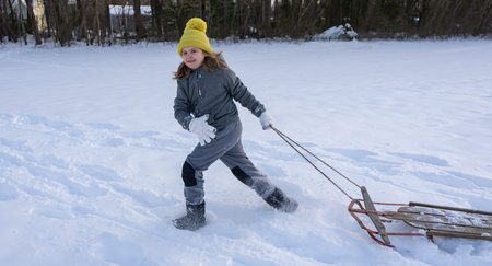 Kid play in the snow. Child near snow winter background. Child in motion in the winter scene. Kid in...